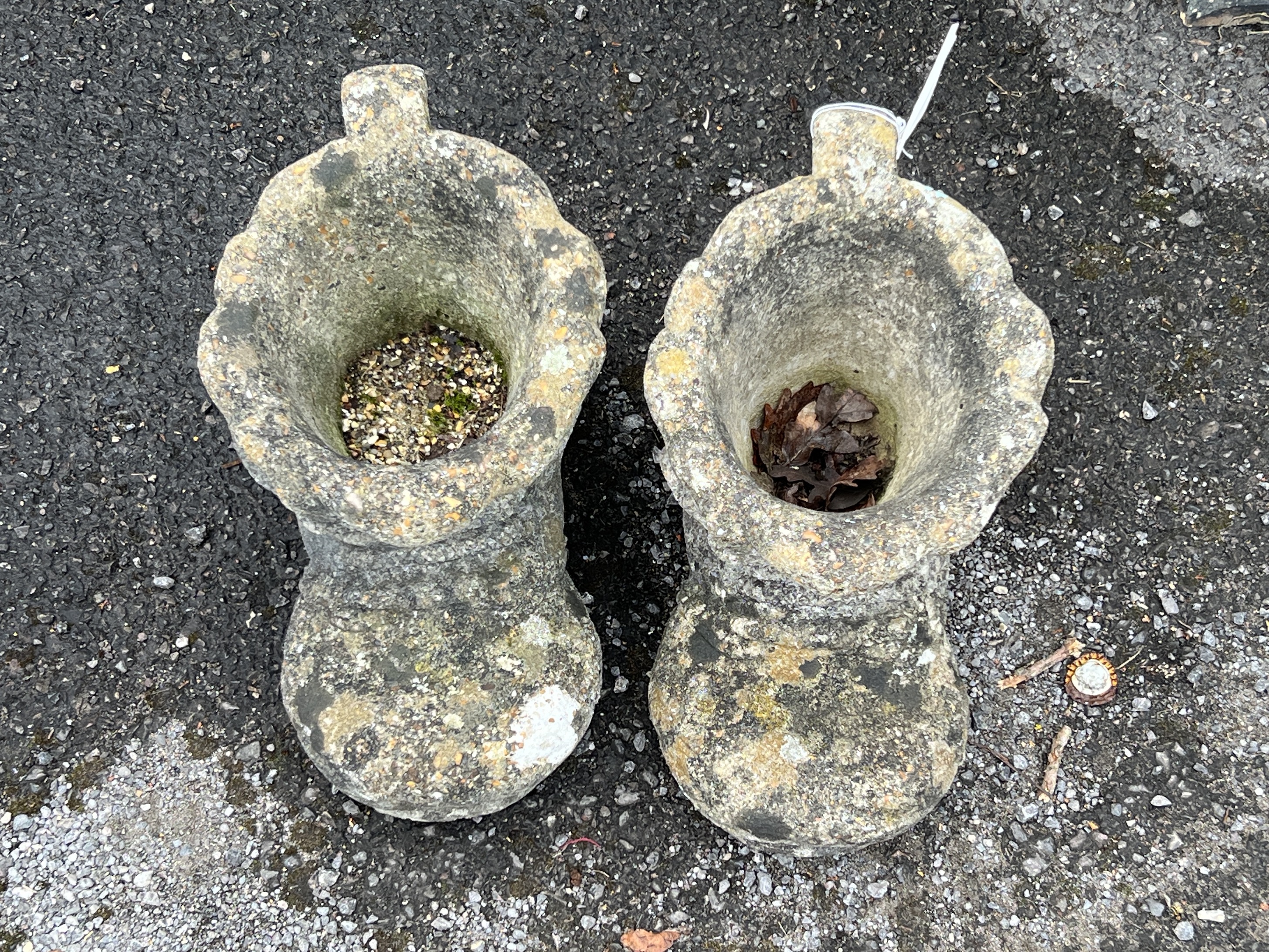A pair of reconstituted stone garden planters modelled as boots, length 37cm, height 21cm